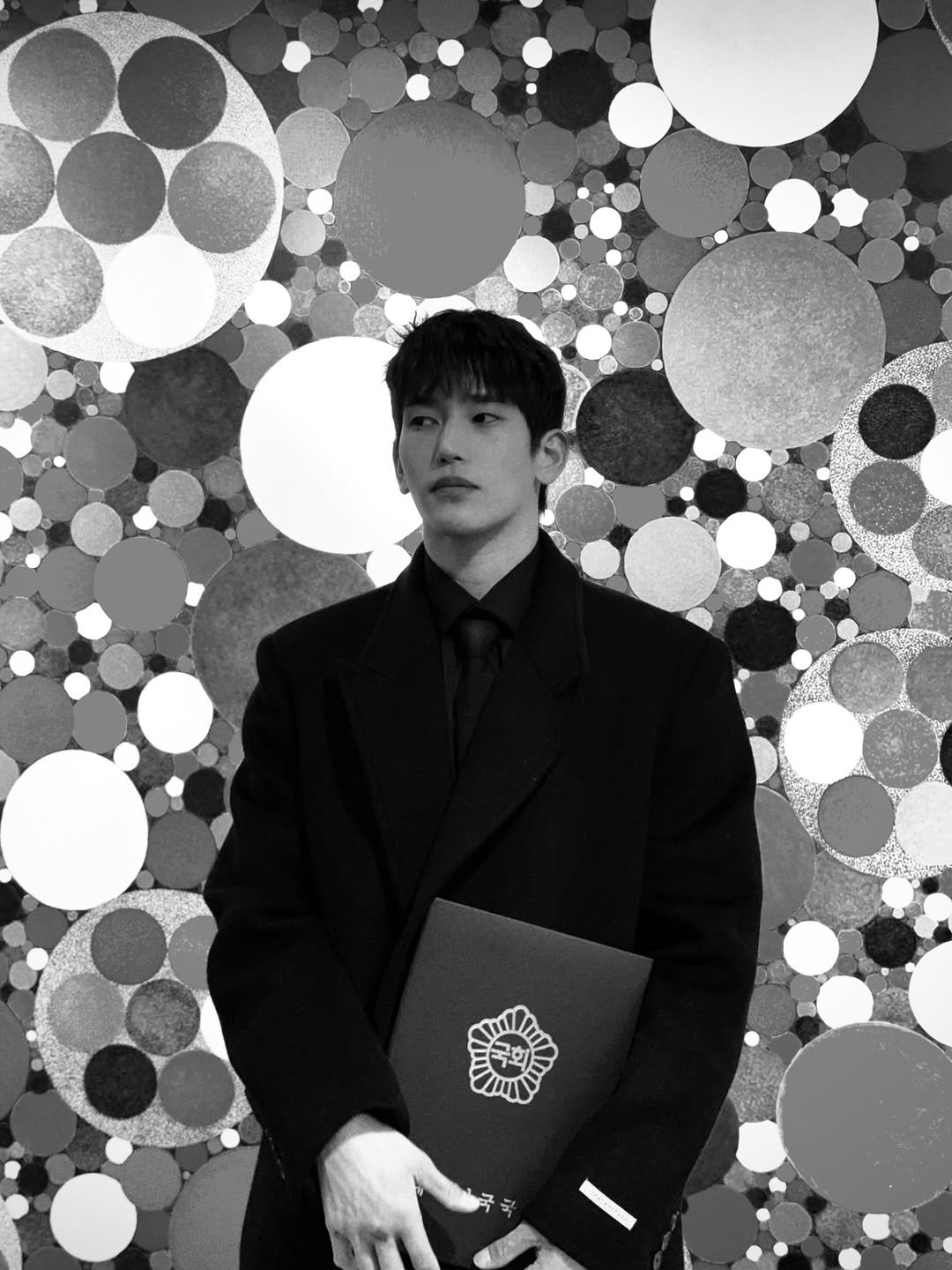 Photo by 육준서 on December 26, 2025. May be a black-and-white image of one or more people, overcoat, blazer, bolo tie, suit, dinner jacket and text.