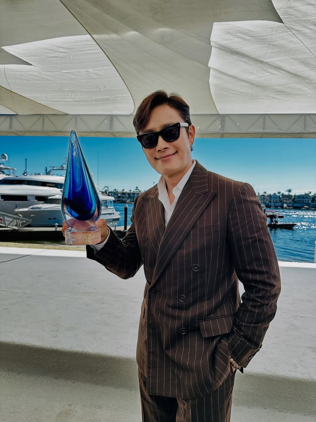 Photo by LeeByungHun 이병헌 on October 20, 2025. May be an image of eyewear, dinner jacket, suit, yacht and text.
