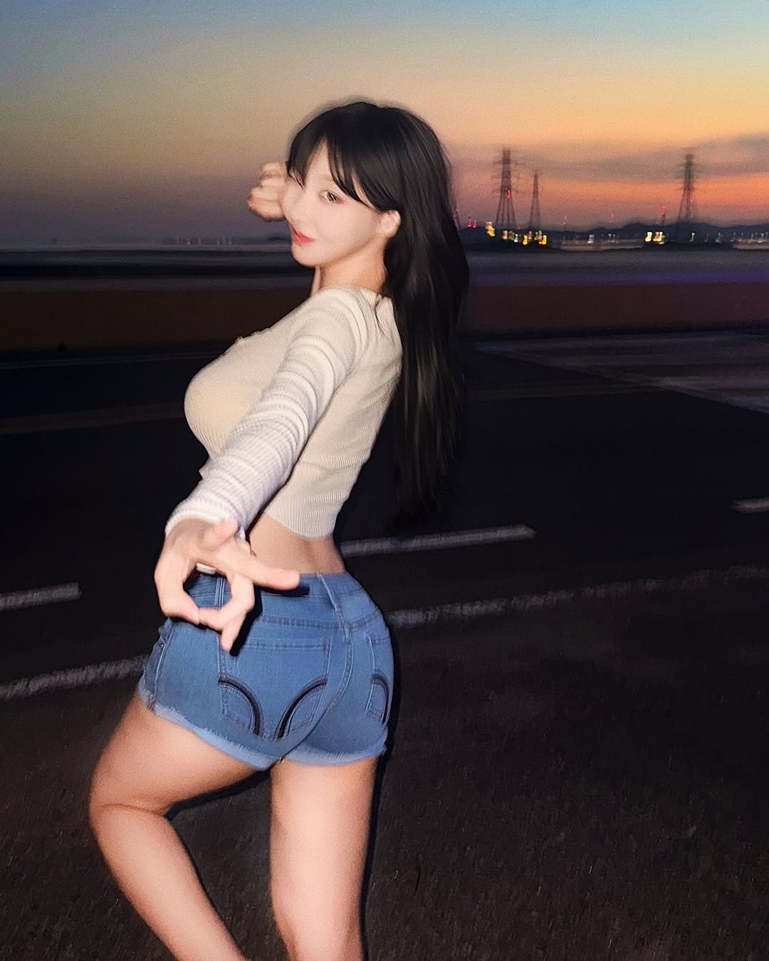 Photo by 갓세희 (20) on July 14, 2025. May be an image of 1 person, hair, shorts, miniskirt, top, road, twilight and text.