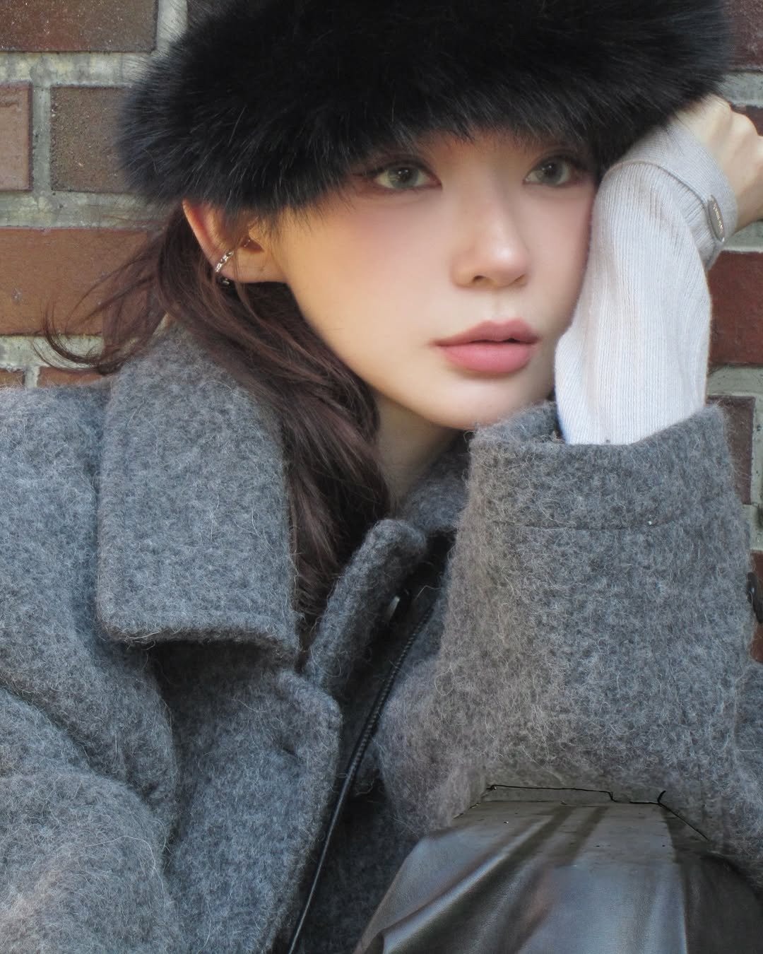 Photo shared by 강민경 (행동파) on November 05, 2025 tagging @aviemuah. May be an image of one or more people, hair, sable coat, goosedown coat, hat, duffle coat, parka, beret and text.