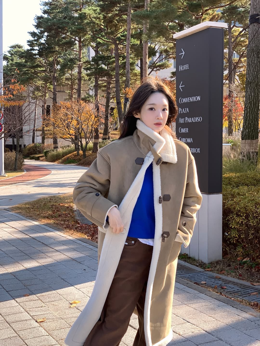 Photo shared by 강민경 (행동파) on November 27, 2025 tagging @raive_studio. May be an image of duffle coat, overcoat, sable coat, scarf, goosedown coat, turtleneck, parka and text.