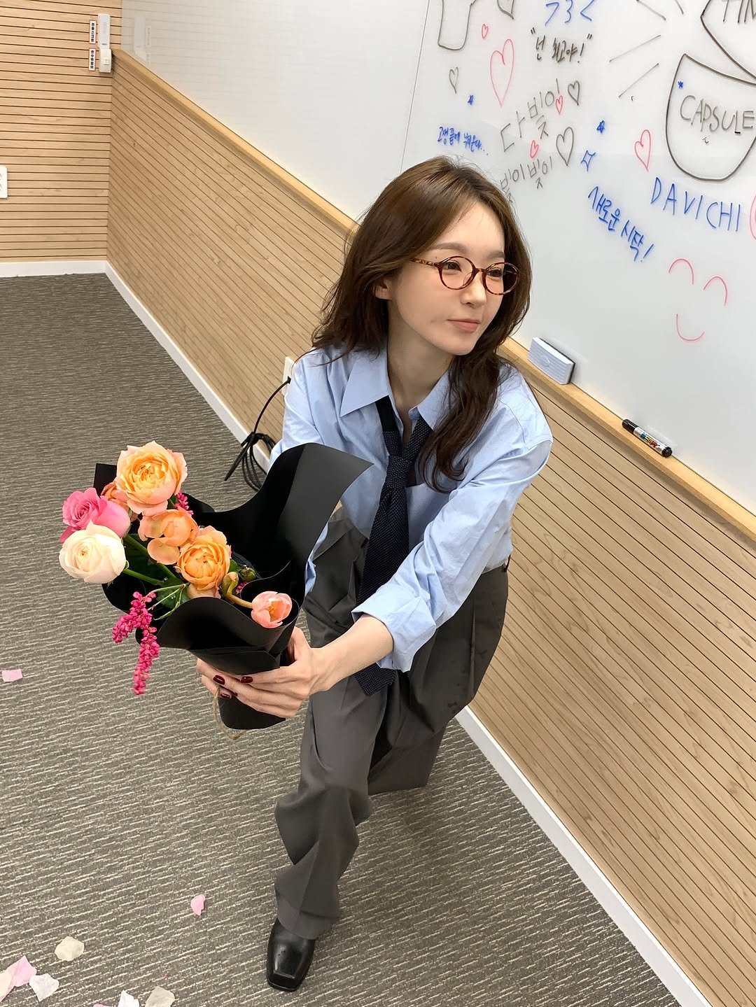 Photo by 강민경 (행동파) on November 12, 2025. May be an image of suit, flower arrangement, prairie gentian, baby's-breath, carnation, rose and text.