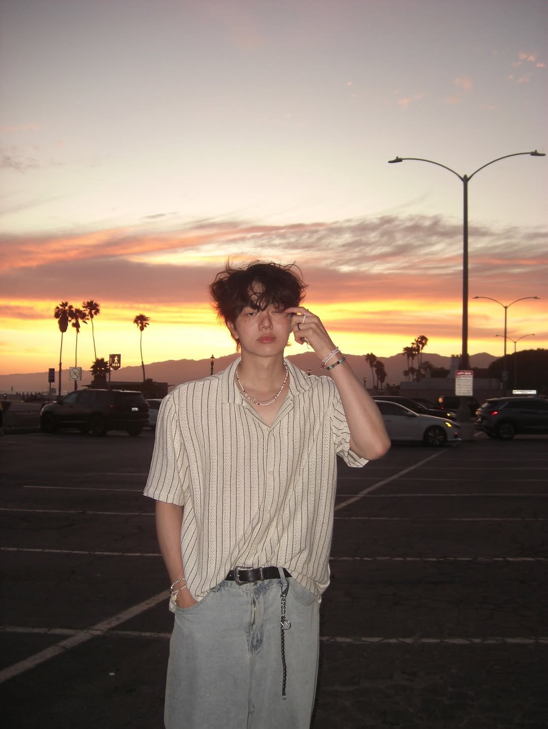 Photo by 사선웅 on July 30, 2025. May be an image of 1 person, bolo tie, palm trees and text.