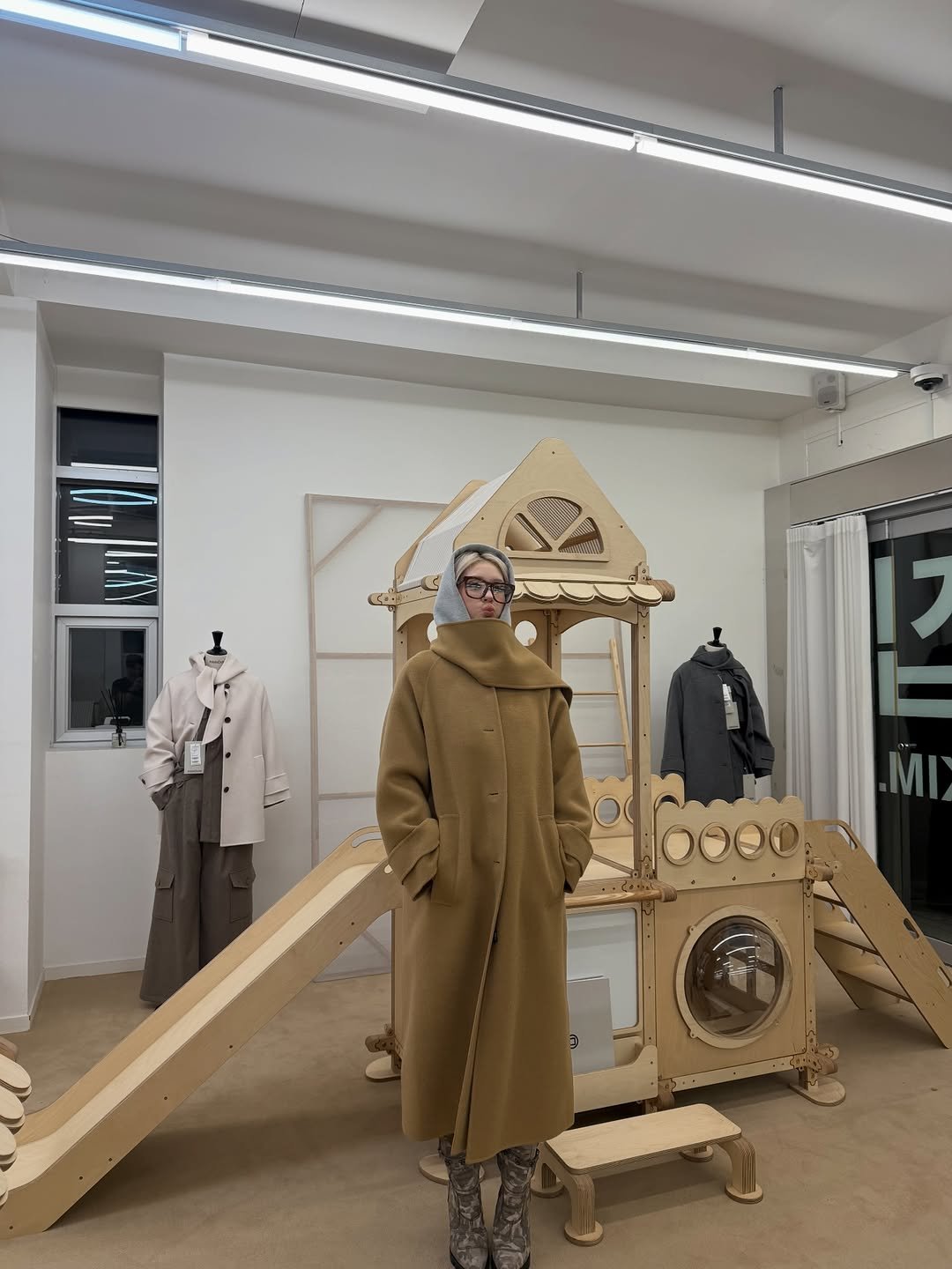 Photo by SOMI on January 10, 2026. May be an image of duffle coat, overcoat, clothes hanger, display case, rack and text.